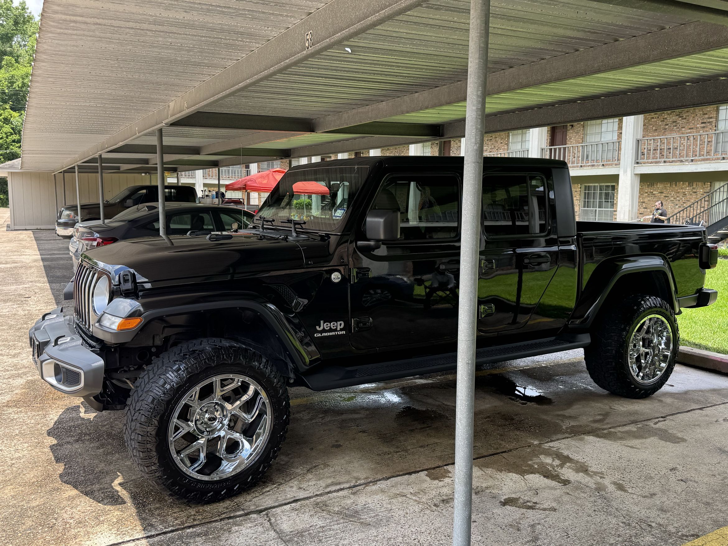 Black Jeep Gladiator front three-quarter freshly detailed